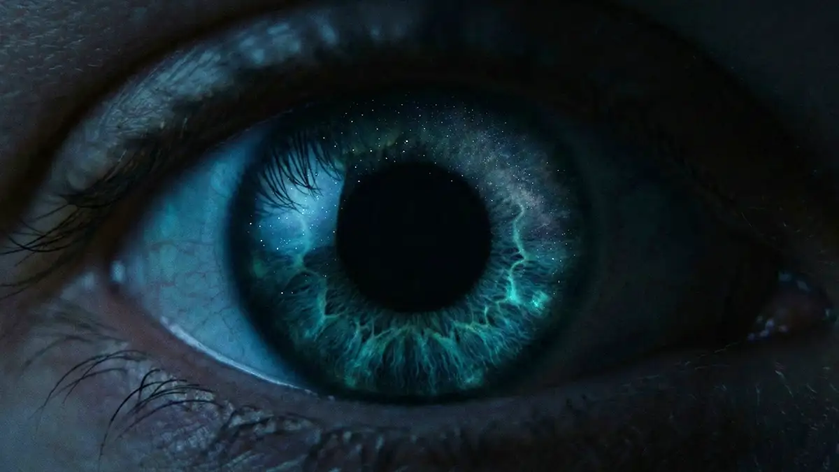 Close-up de um olho humano com a pupila dilatada adaptando-se para a visão noturna.
