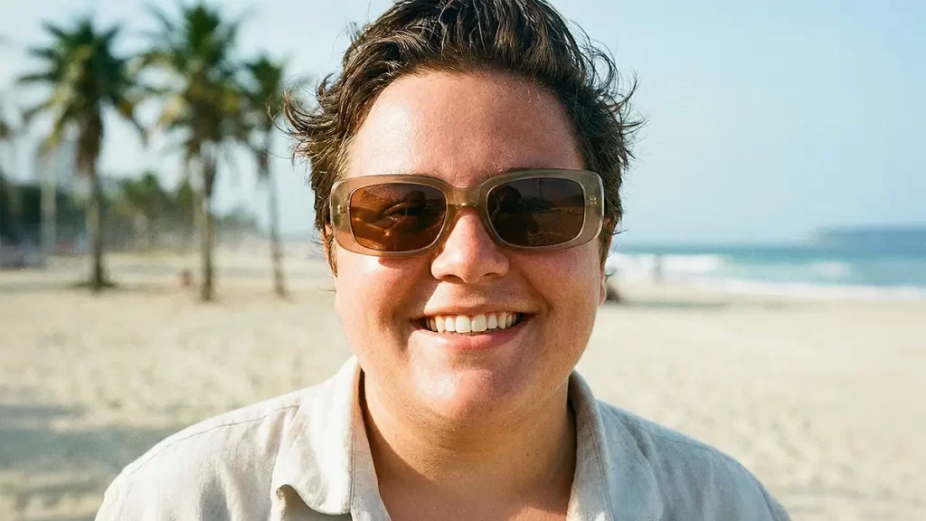 Modelo com rosto redondo usando óculos de sol retangulares que alongam o rosto